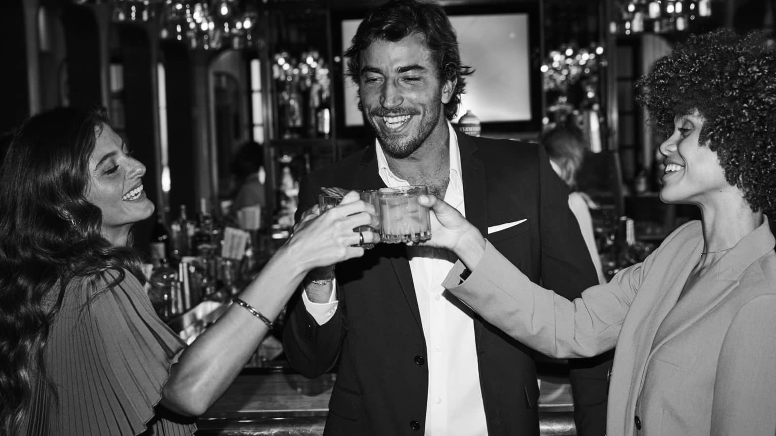 Three guests raising their glasses and smiling at one another.