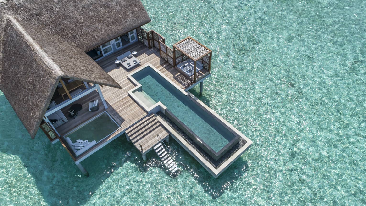 Aerial view of lure island villa with private pool and deck surrounded by crystal ocean