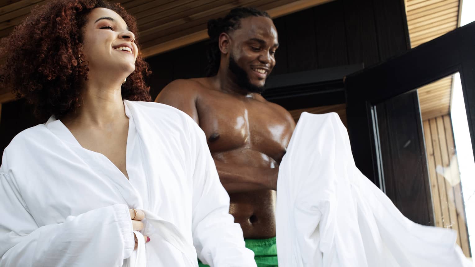 Man and woman smile wearing spa robes