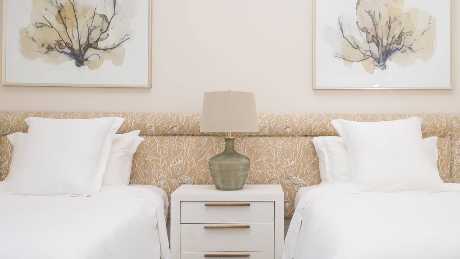 Bedroom with two single beds and floral artwork