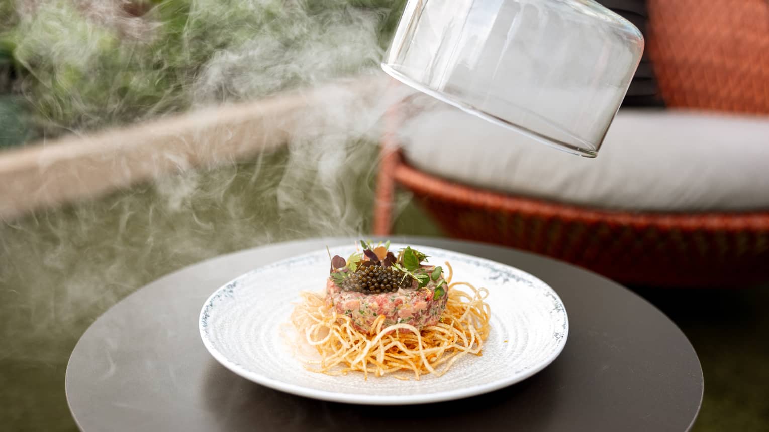 Pouring steaming noodles onto a plate.