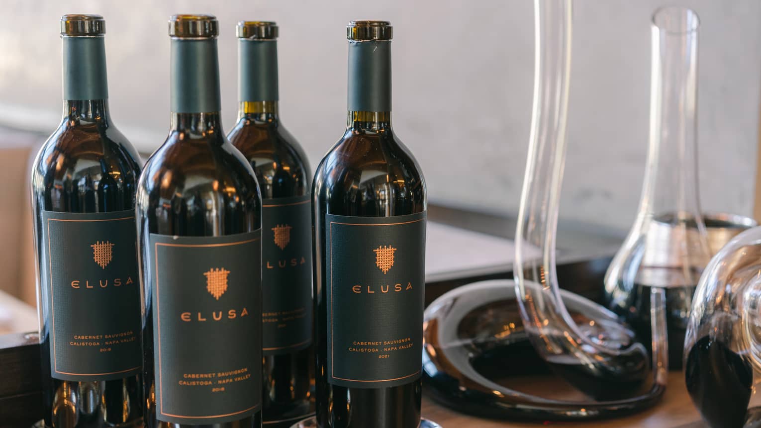 Four bottles of Elusa Wine set on a table