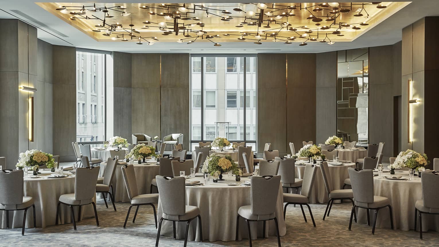 Round tables, chairs under brass ceiling with lights in Greenwich Ballroom