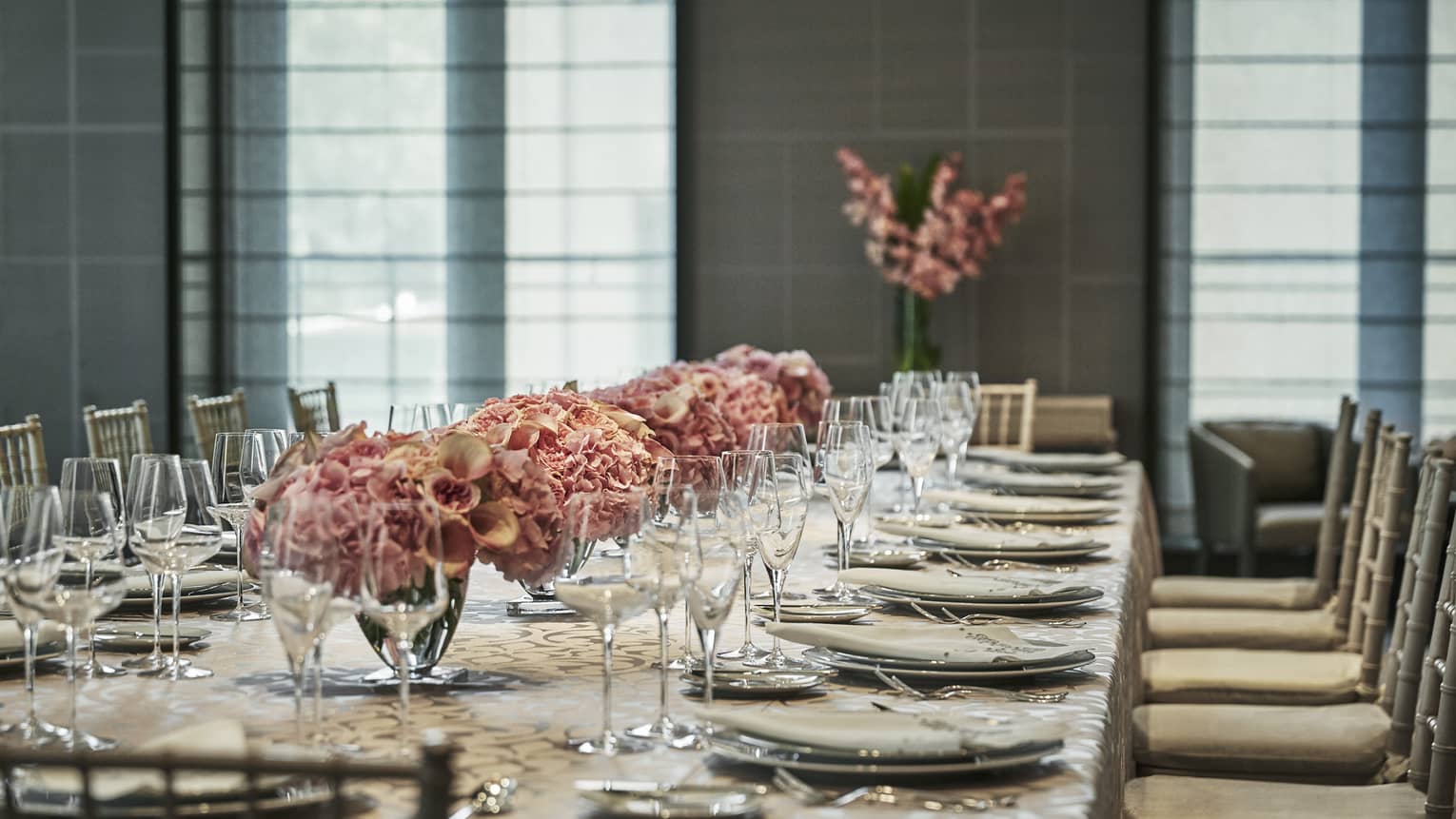 Banquet table with elegant dishes, wine glasses, pink floral arrangements in Chambers room