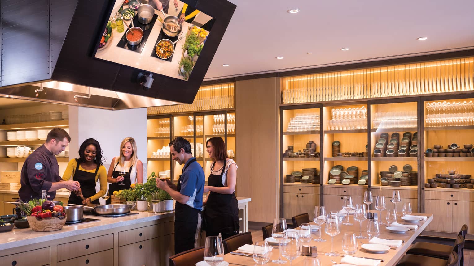 People wearing aprons gather around counter in Ravello Demonstration Kitchen 