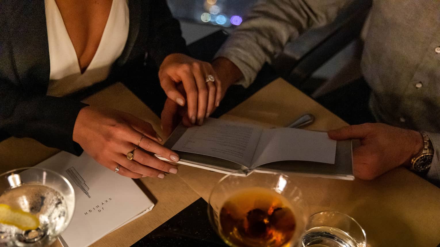 A couple holding hands at a dinner table.