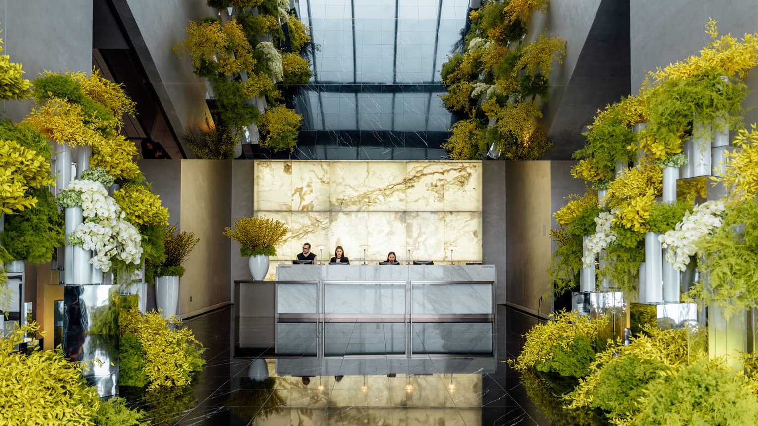 A hotel lobby with yellow flowers lining the hallway