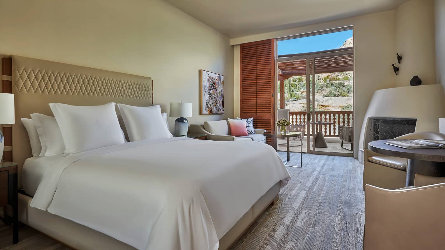 King-bedded room with wooden floors and a walk-out patio
