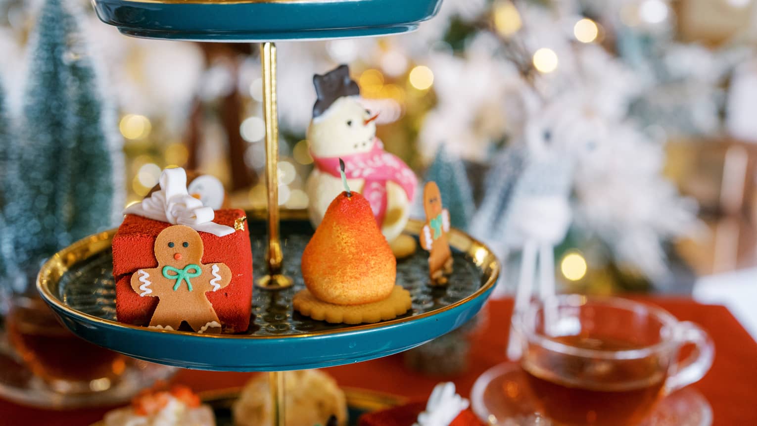 A three-tiered display with a gingerbread cookie and desserts