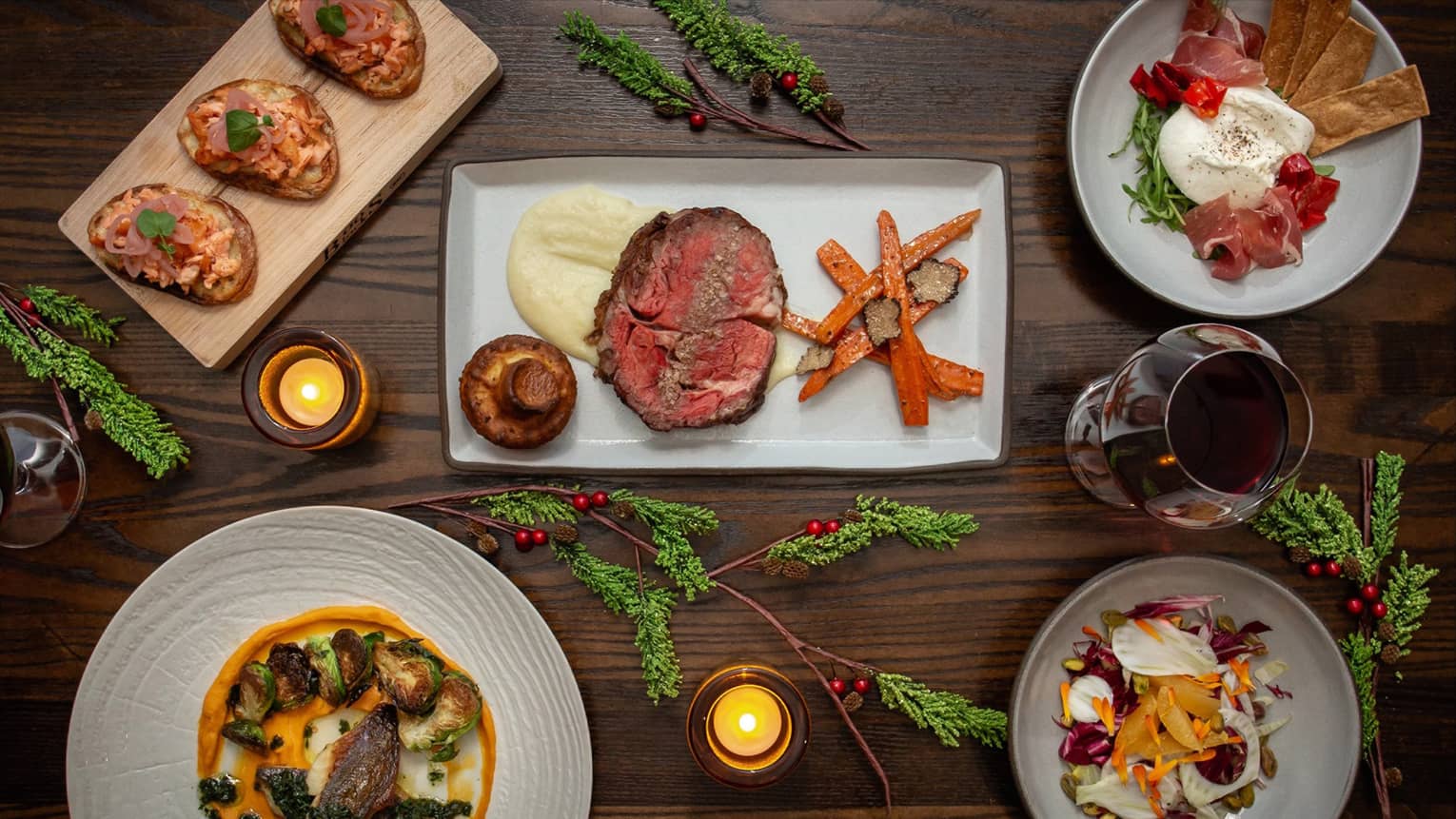 An assortment of holiday food on white and wood trays.