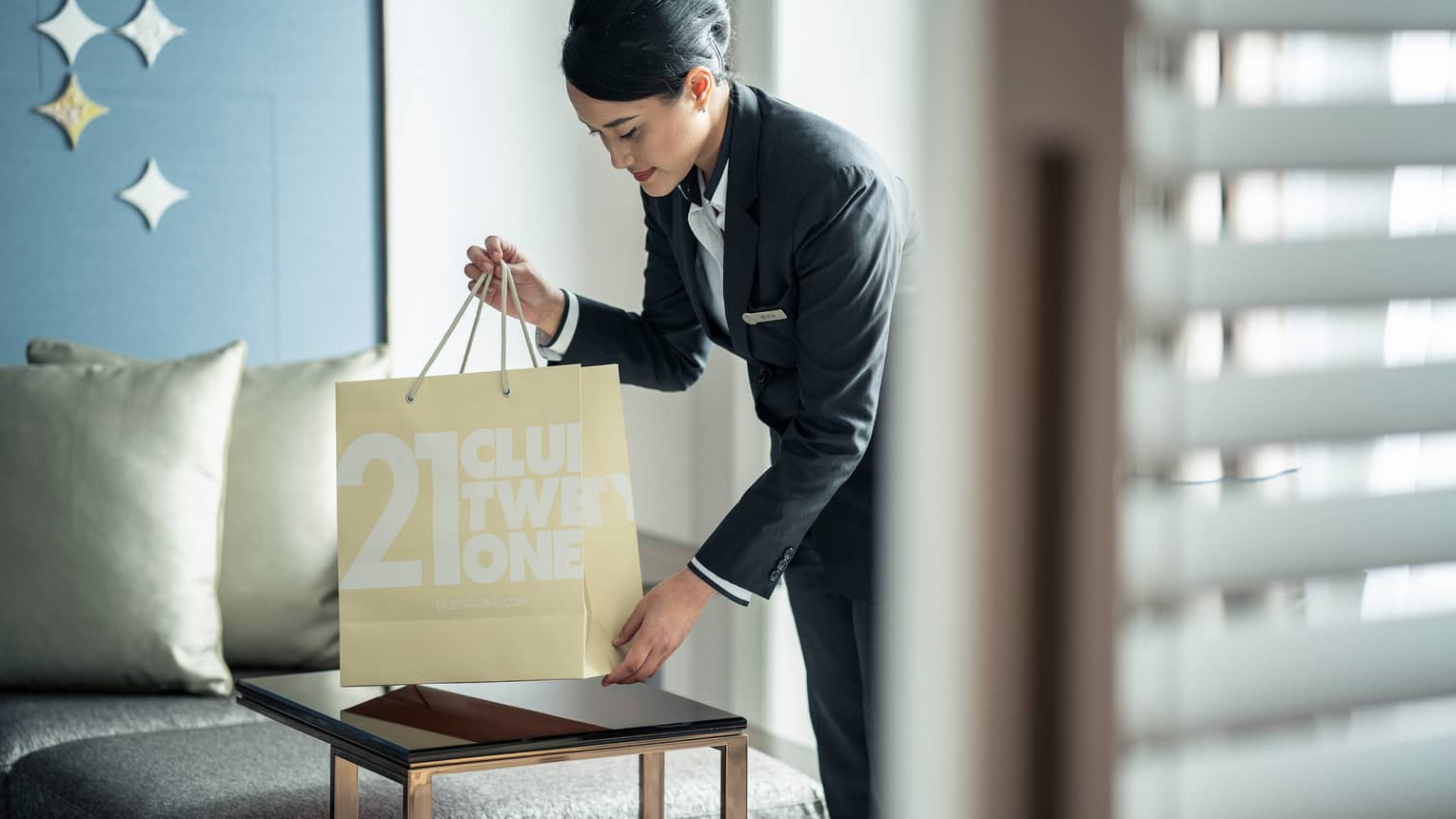 Hotel staff pours coffee from carafe into cup on brunch tray on in-room dining table