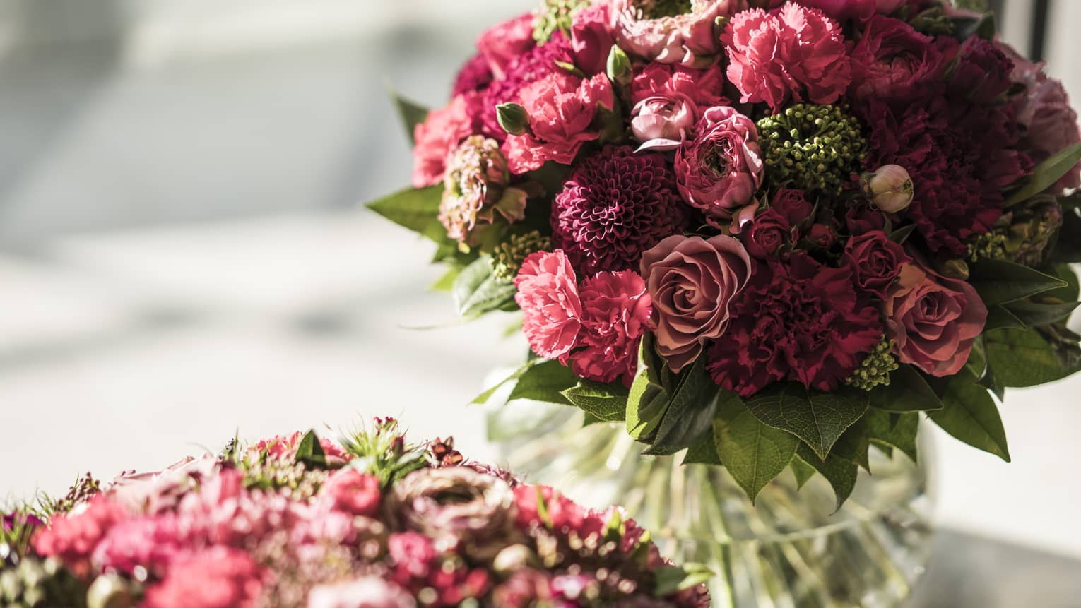 Closeup of two mauve and red floral bouquets in vases