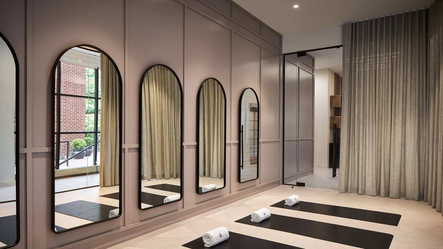 Yoga mats in a yoga studio with mirrors on the wall.