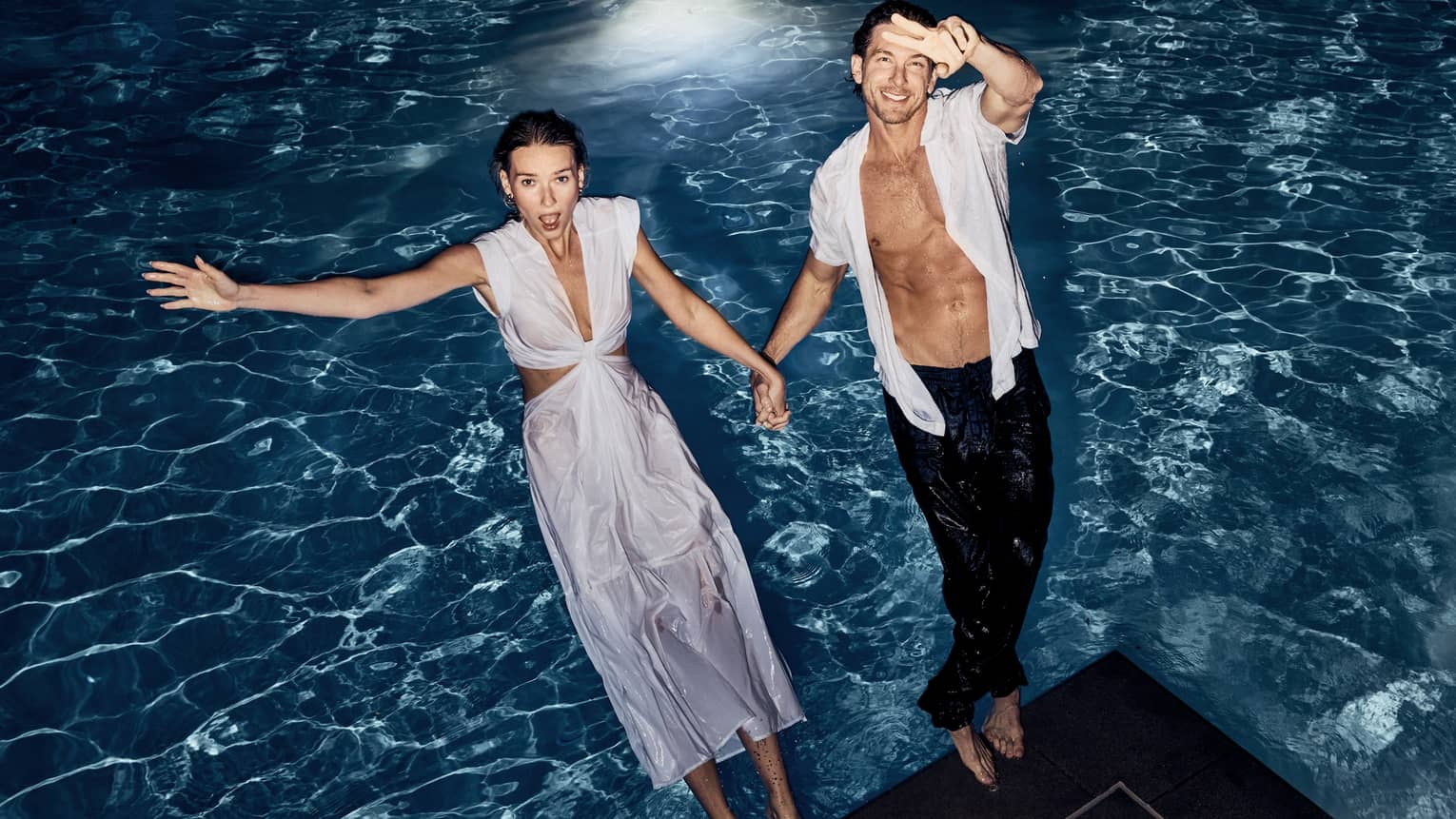 Two guests jumping into the pool.