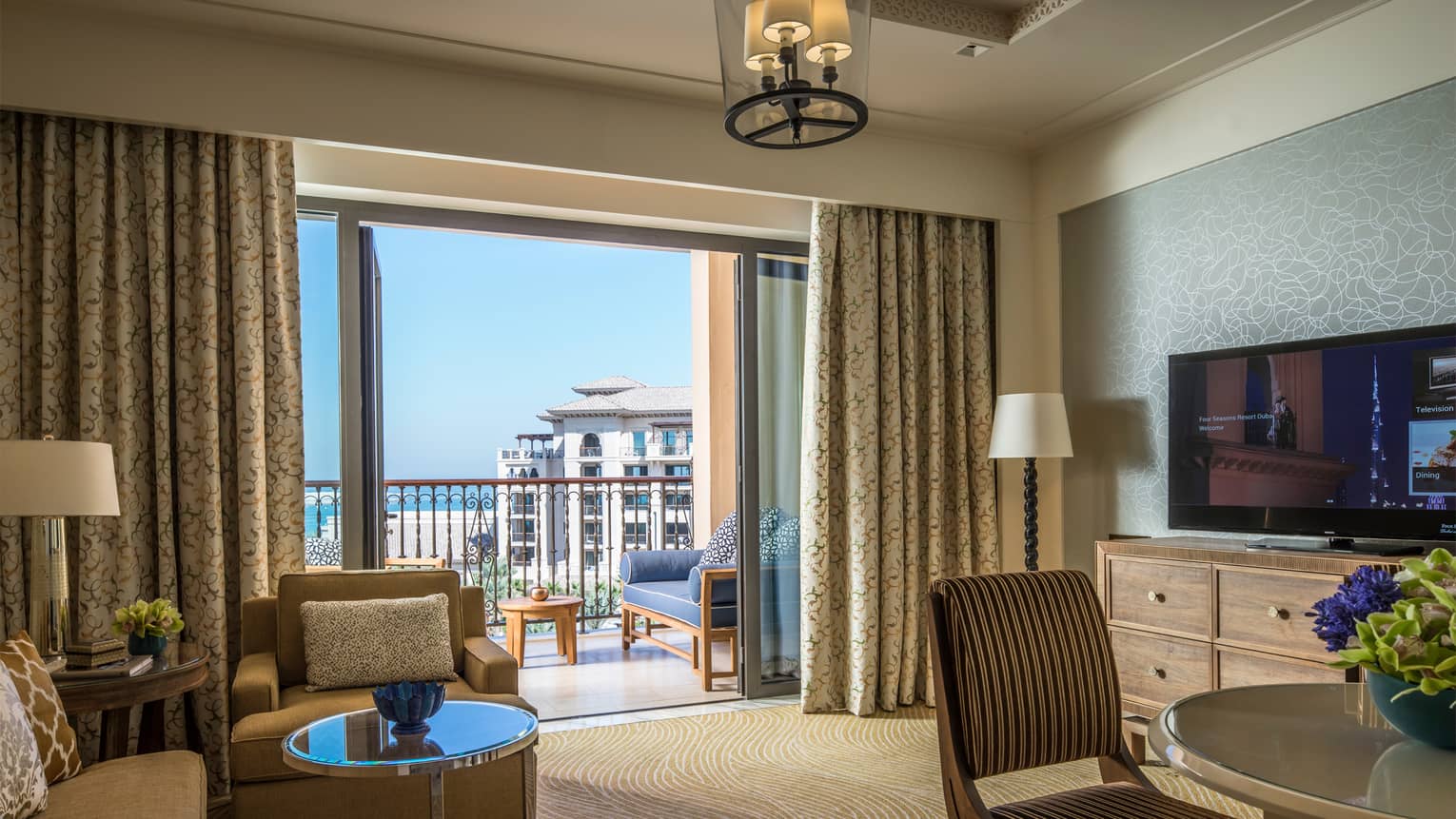 Four Seasons Sea-View Suite with large living and dining space, flat-screen TV, balcony