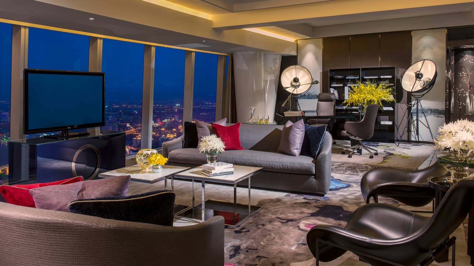 Presidential Suite at night, two sofas, modern black accent chairs near large office area, window