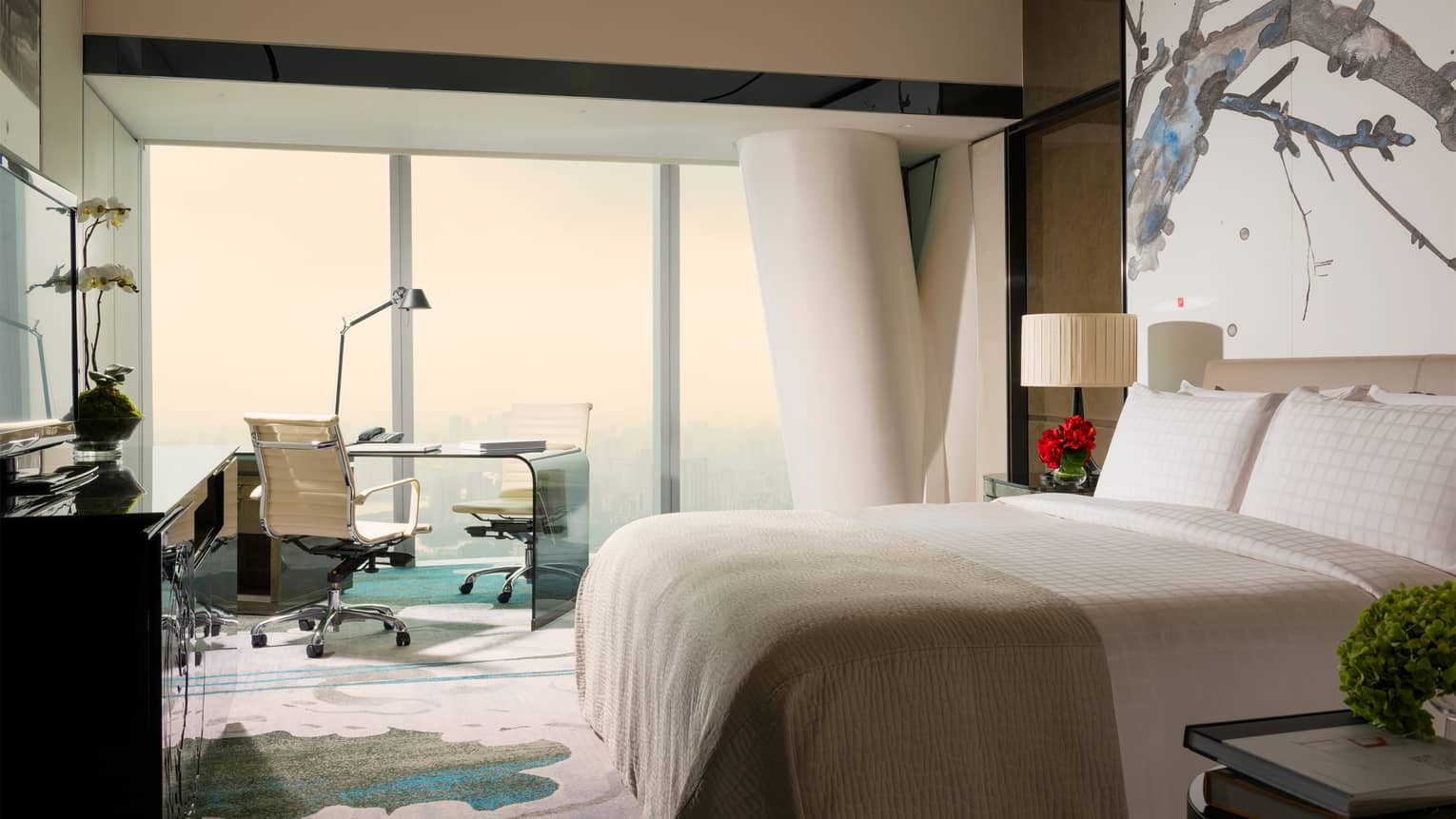 Tower Room with View bright decor with white bed, white and blue carpet and art, floor-to-ceiling window