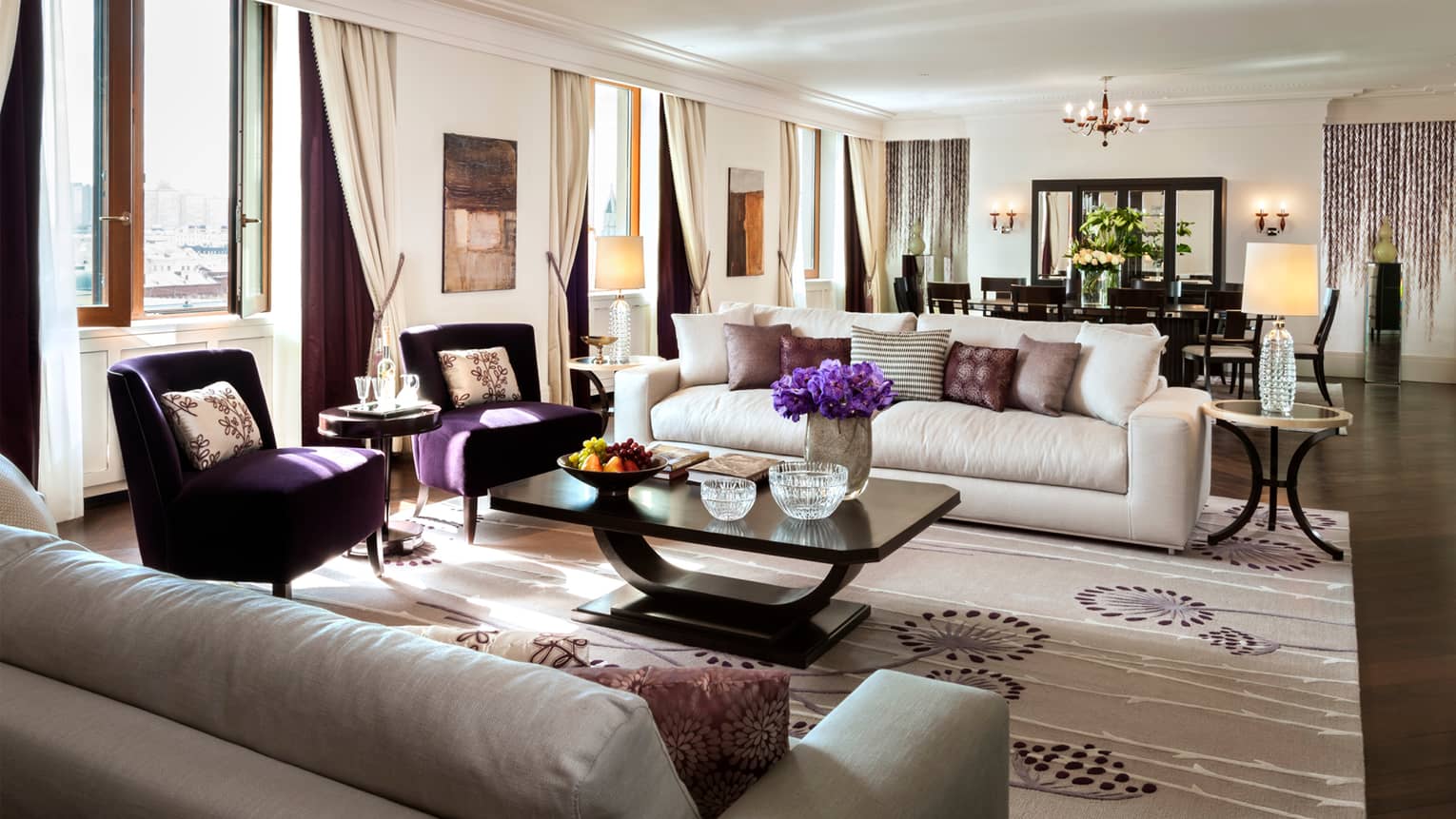 Imperial Suite living area with white sofas, dark purple armchairs, private dining table for 10