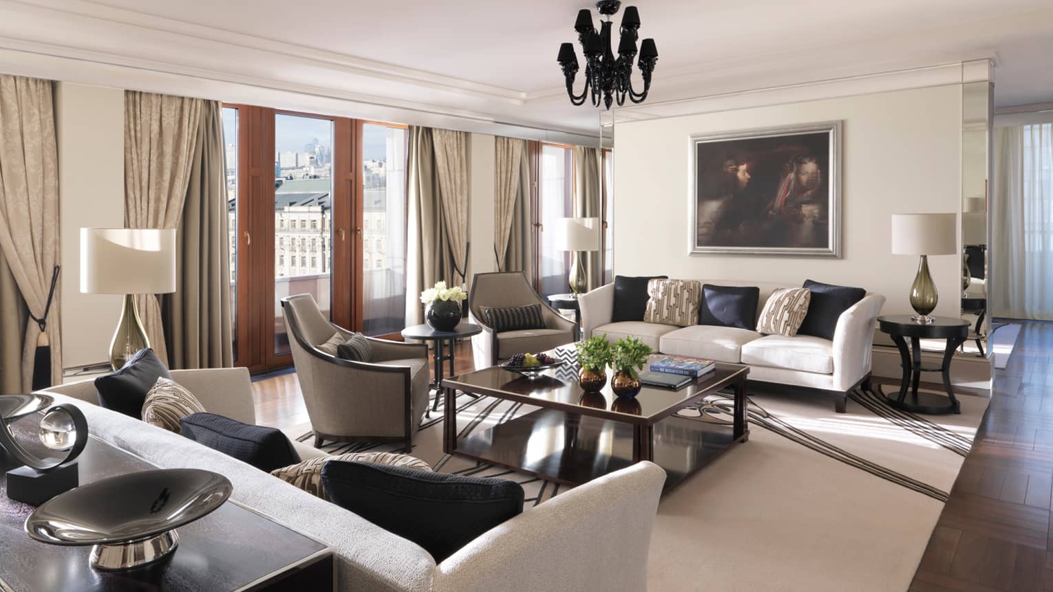 Sunny Minin Presidential Suite living area with white sofas, grey chairs, brass coffee table and vase