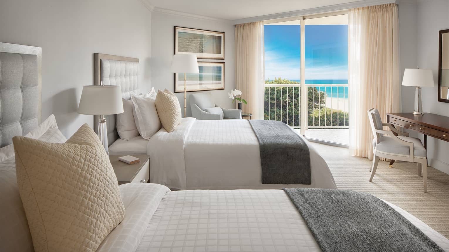 Ocean-View Room with double beds, grey padded headboards and gold pillows, balcony door with beach view
