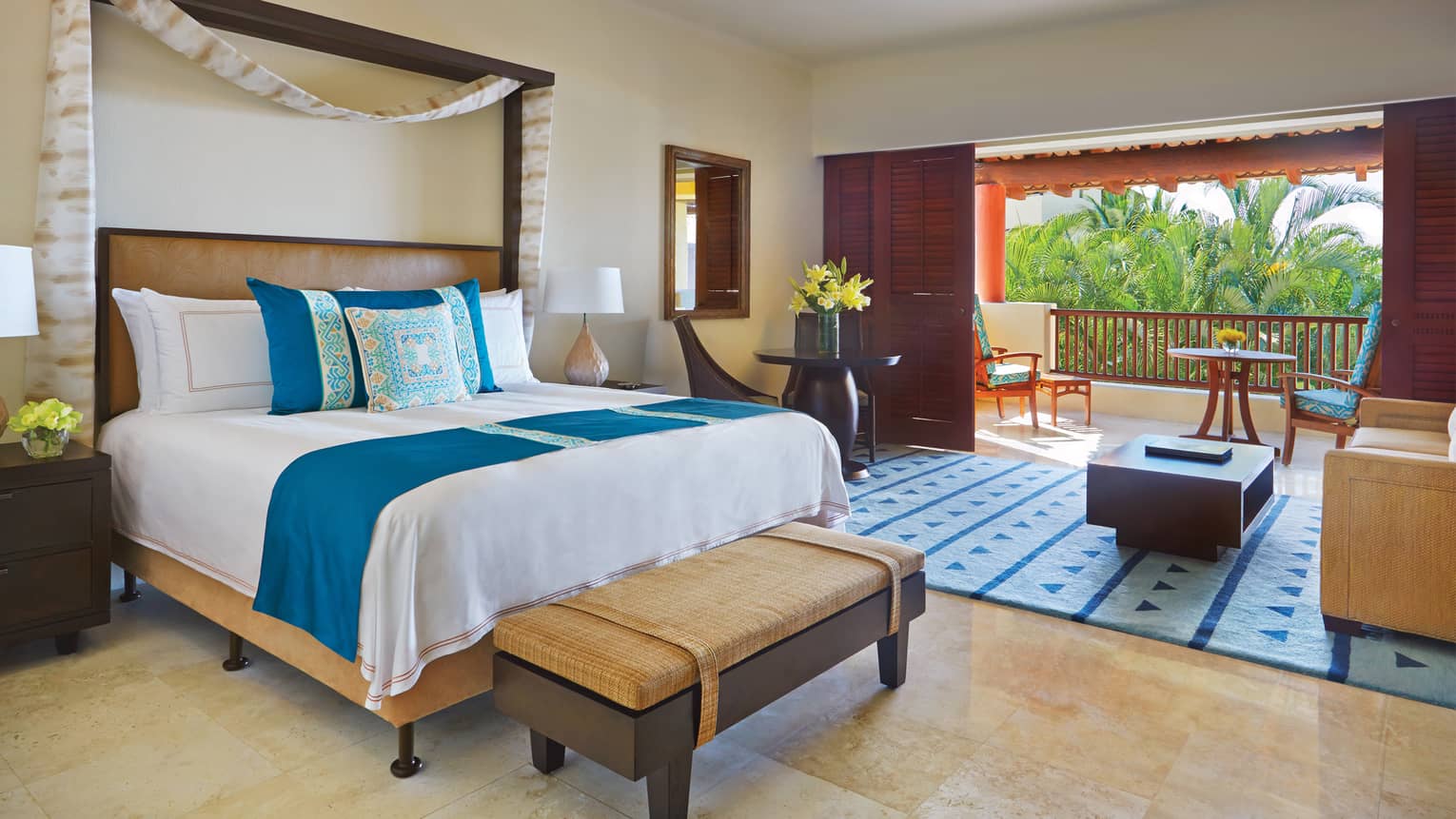 Garden-View Casita bed with blue-and-yellow Mexican print pillows, living room, sliding wood doors to patio