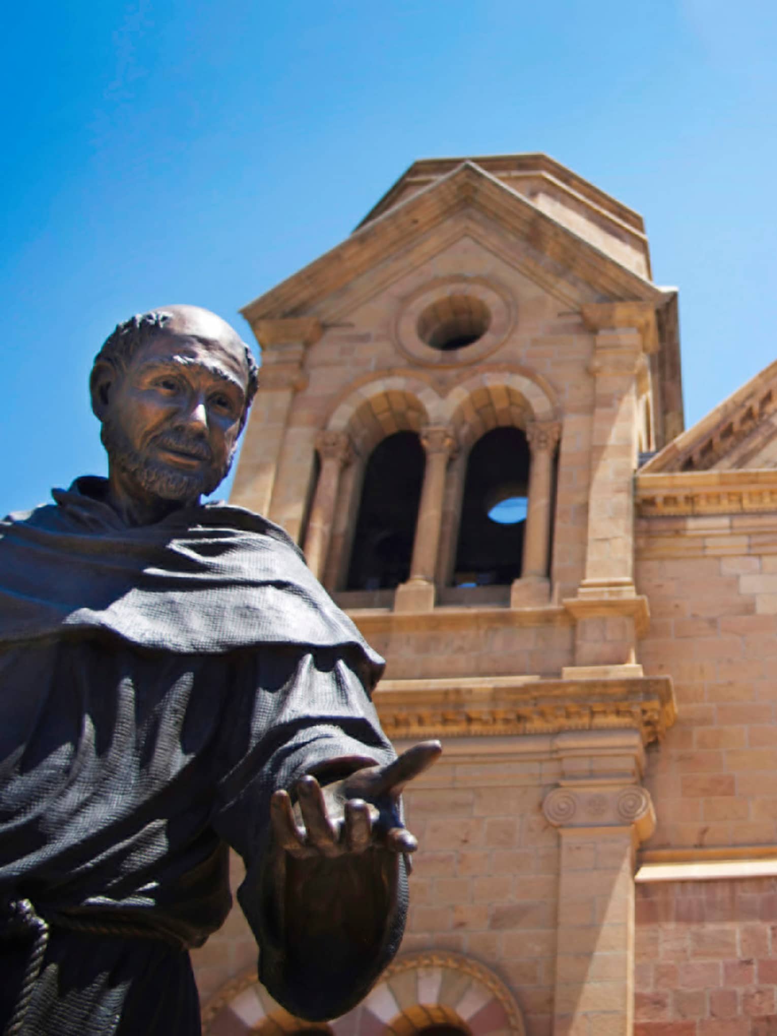 Statue of monk in front of stone New Mexico cathedral church