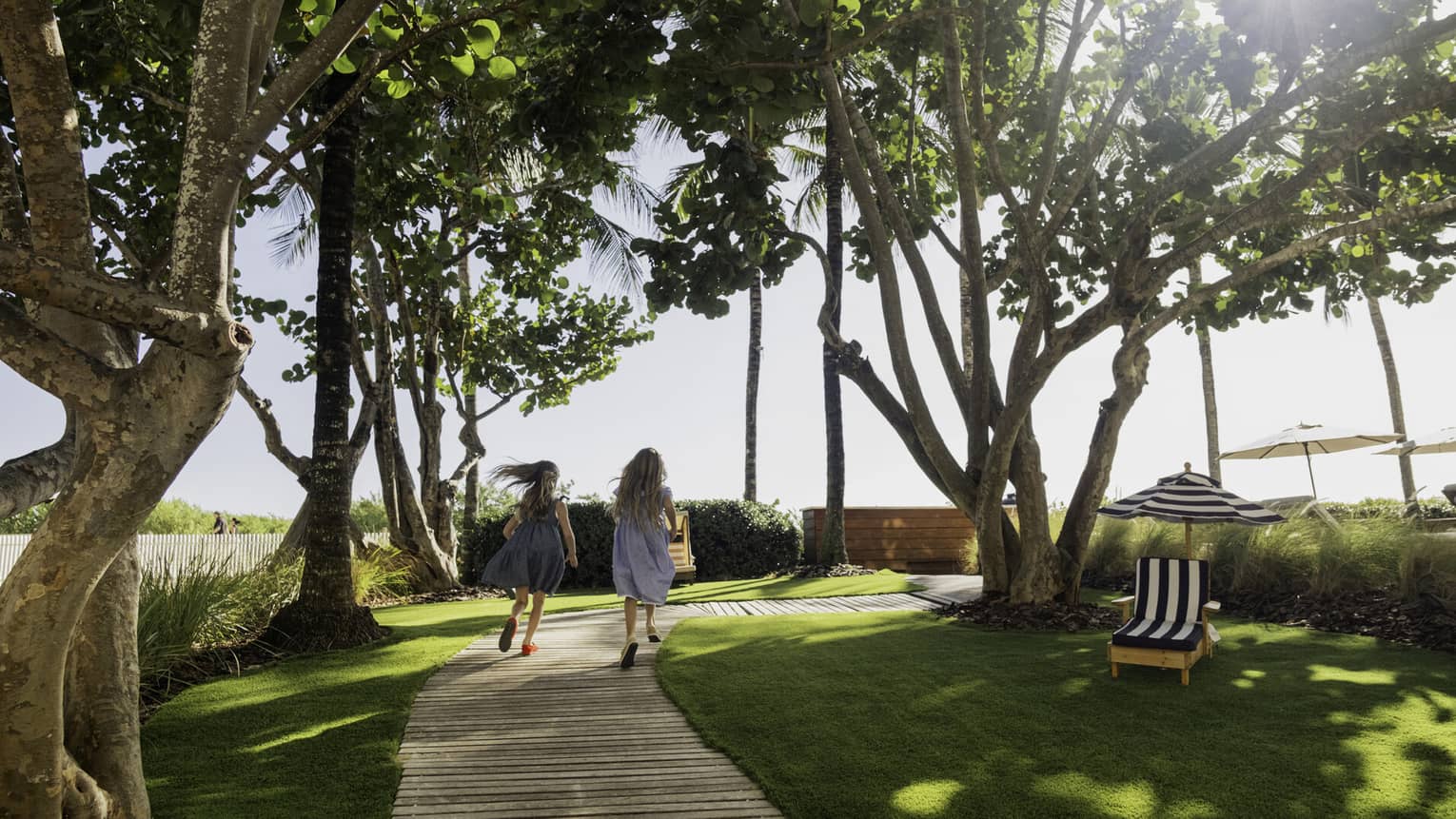 Two young guests running along a path surrounded by trees