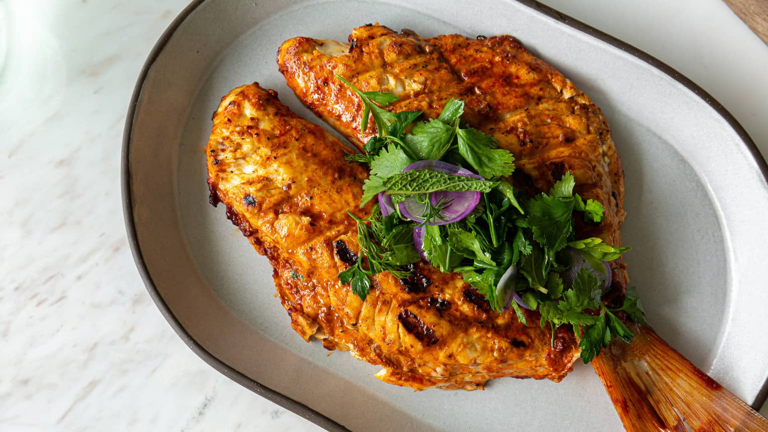 Cooked fish on a white plate.