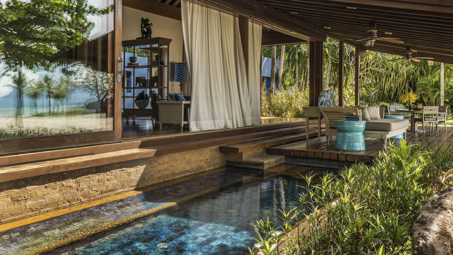 White curtains hang from Beach Villa patio over tile plunge pool