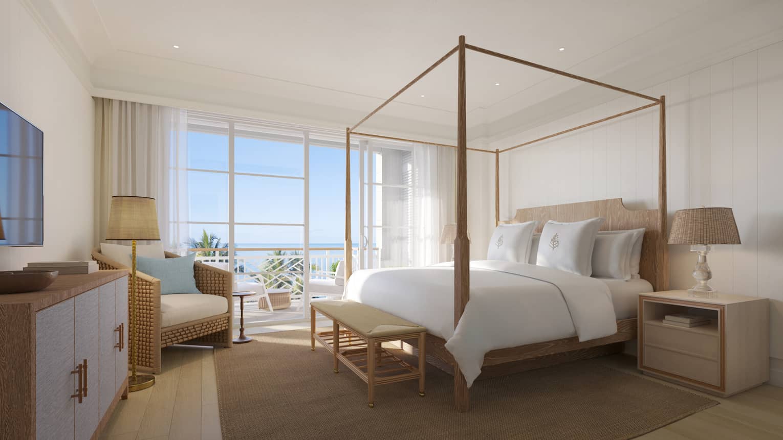 Modern resort suite with four-post king bed, arm chair and ocean-view terrace