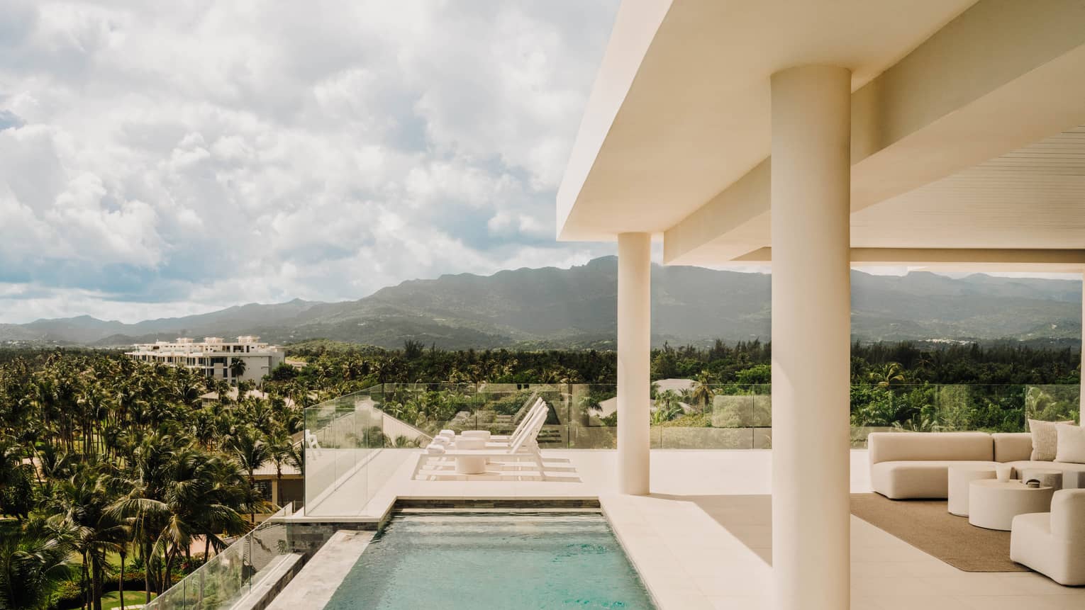 Infinity pool on a modern terrace overlooking lush resort grounds