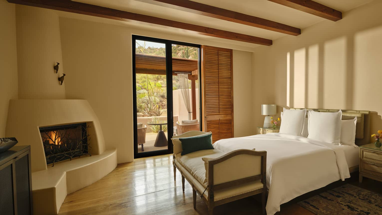 Bedroom with a king bed, chaise, fireplace and walk-out terrace
