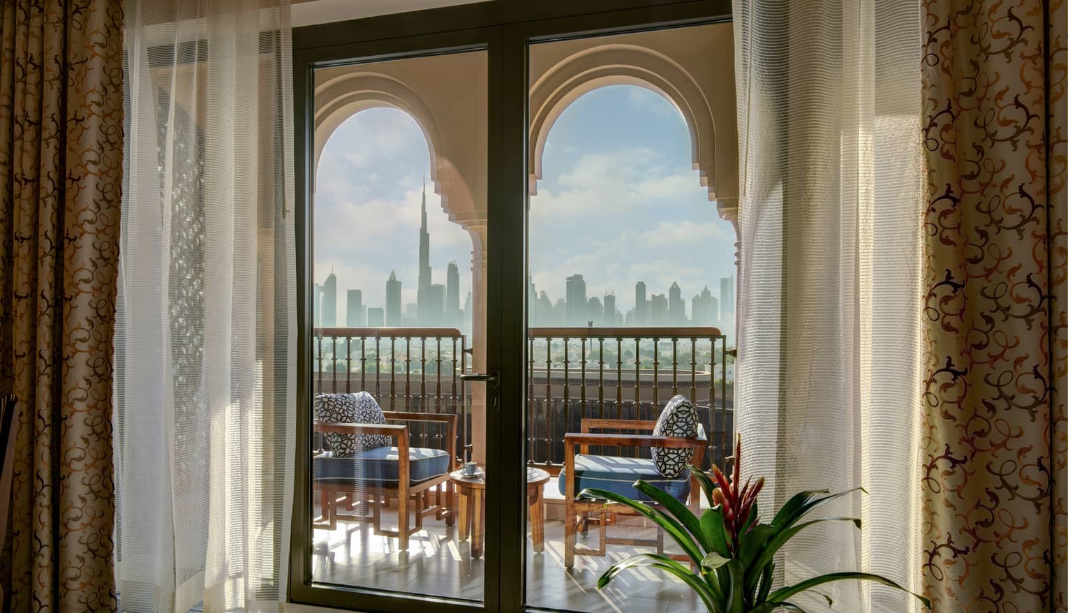 Glass doors lead out to private balcony with two chairs