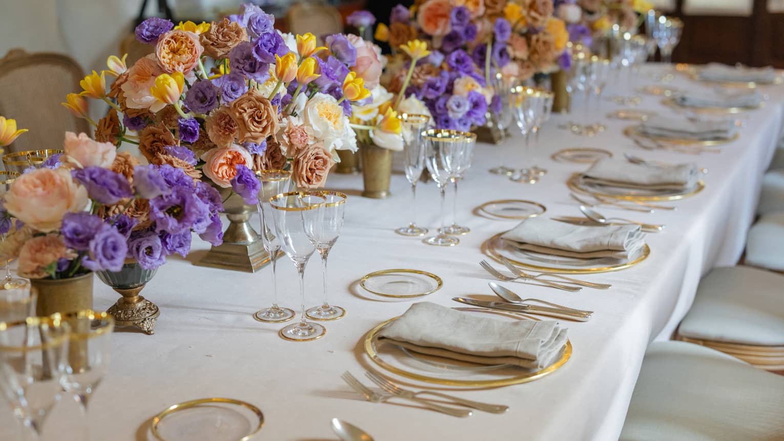 Elegantly set formal banquet table with colourful flower centrepieces