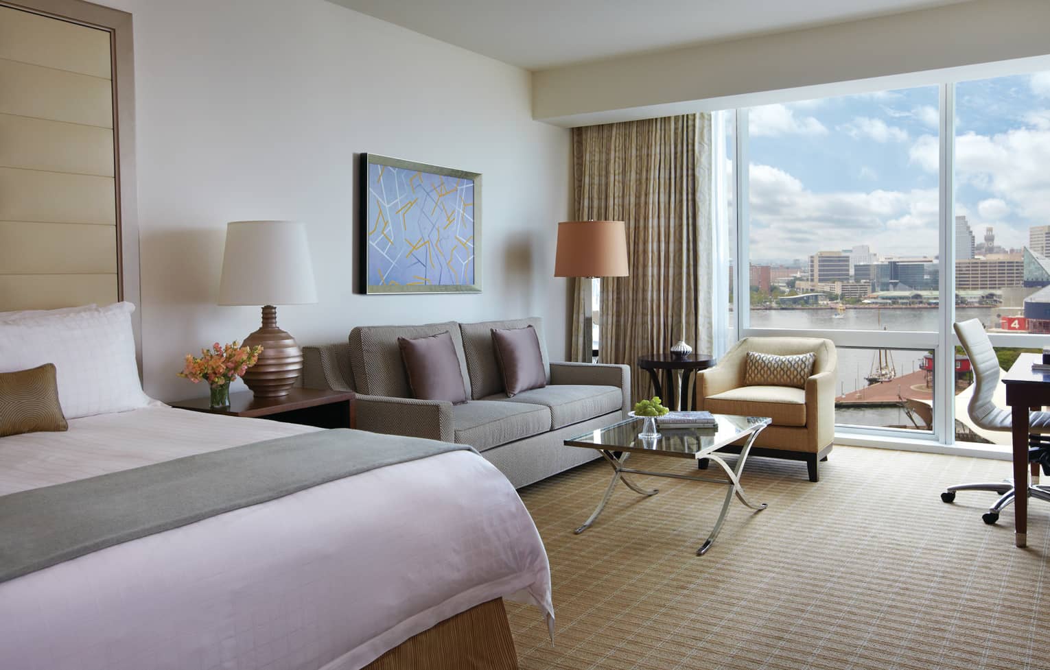 Harbour View hotel room end of bed with sash, loveseat chair by glass wall, balcony