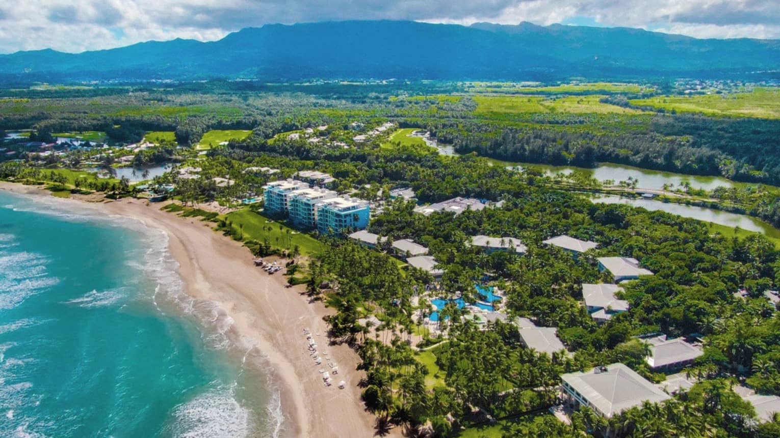 Aerial view of Residences building, beach and ocean with mountains in the background