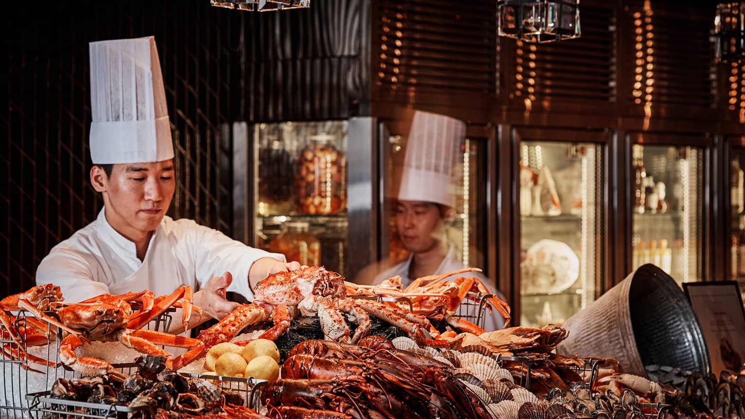 Chefs arrange large fresh crabs on ice at The Market Kitchen seafood buffet