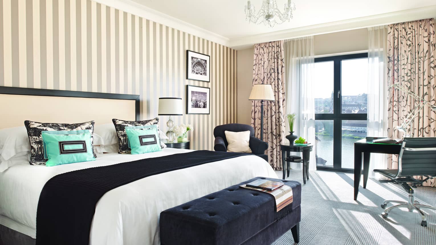 Premier Room with black, white and turquoise decor, grey-and-white striped wallpaper, bed, chair and desk