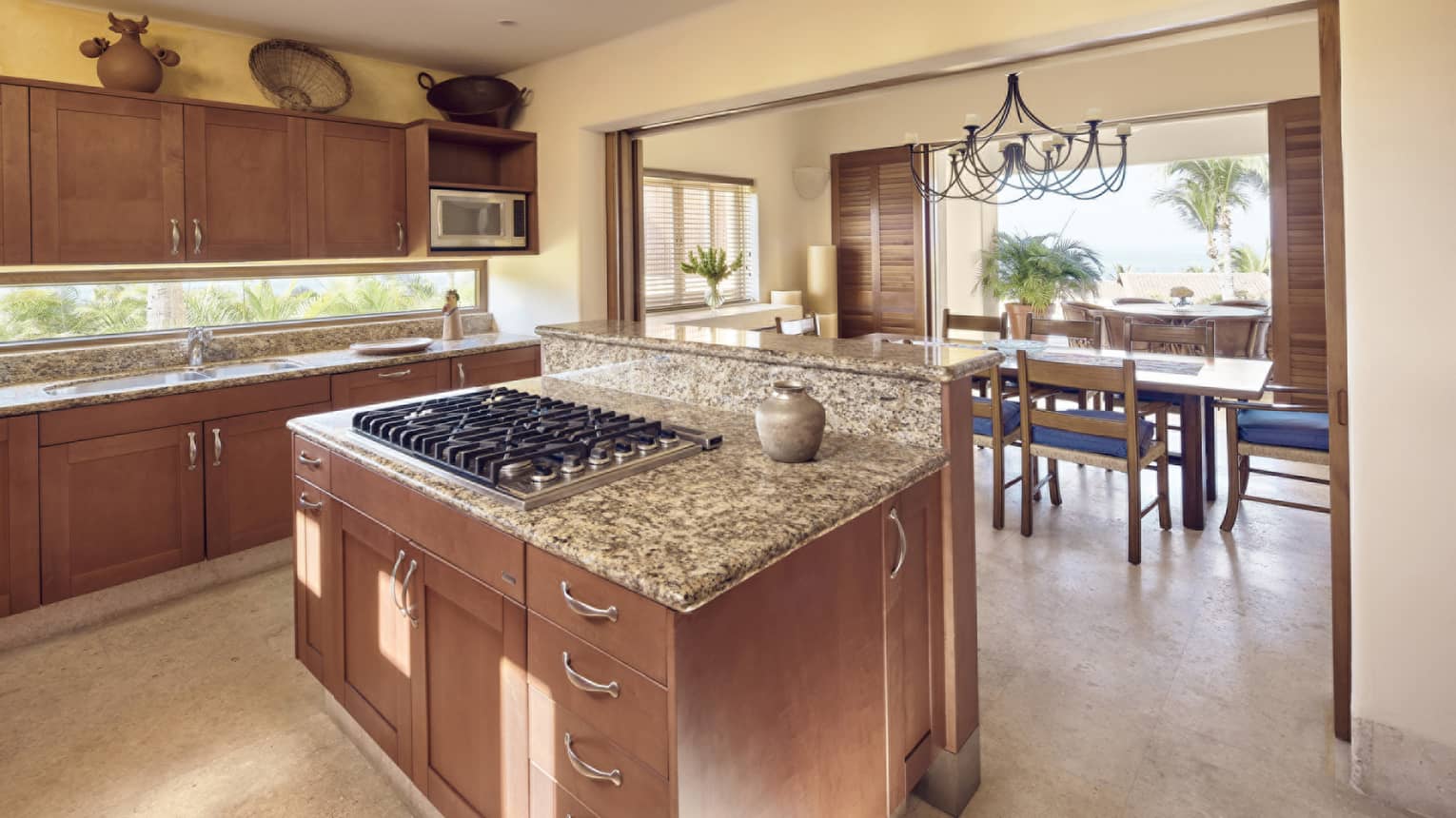 Kitchen island with gas range on it, entryway into dining room