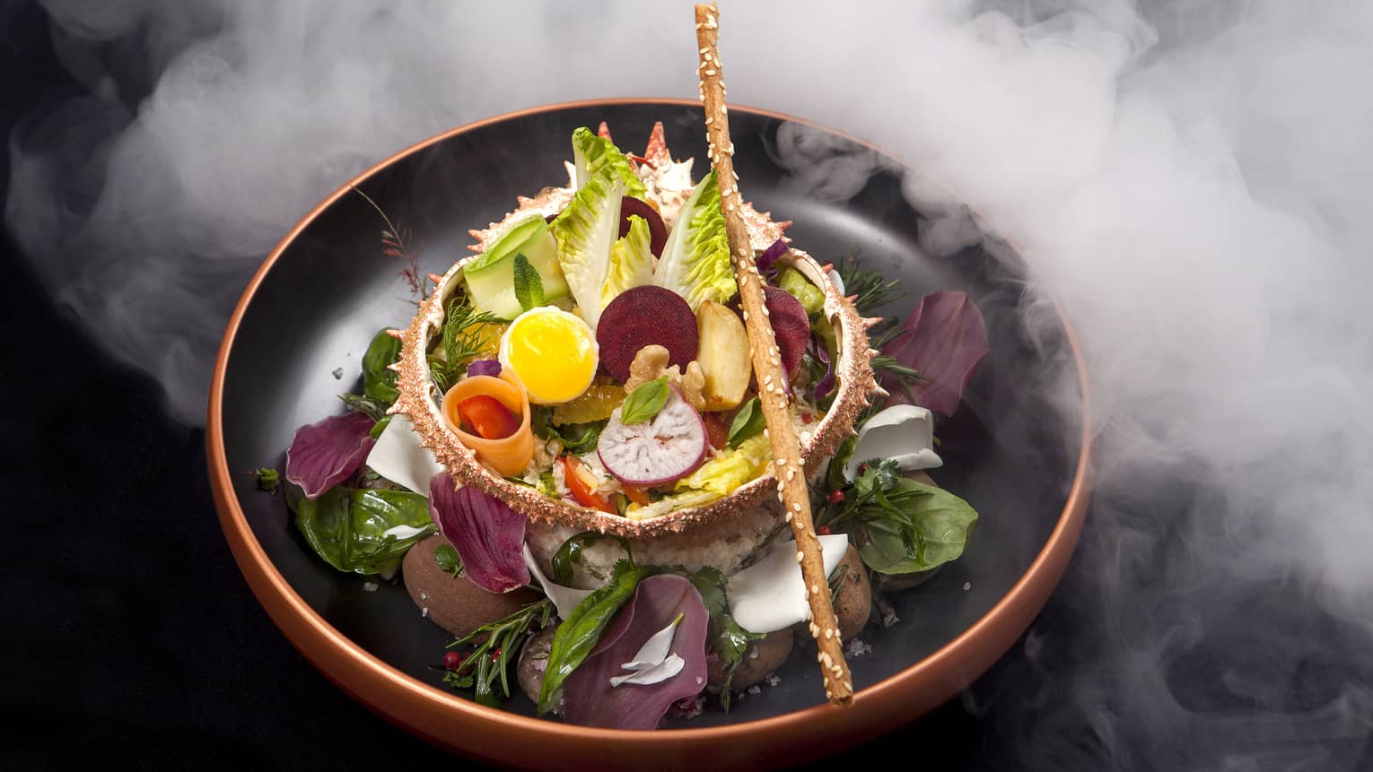 Gourmet salad with root vegetables, boiled eggs, breadstick in bowl surrounded by steam