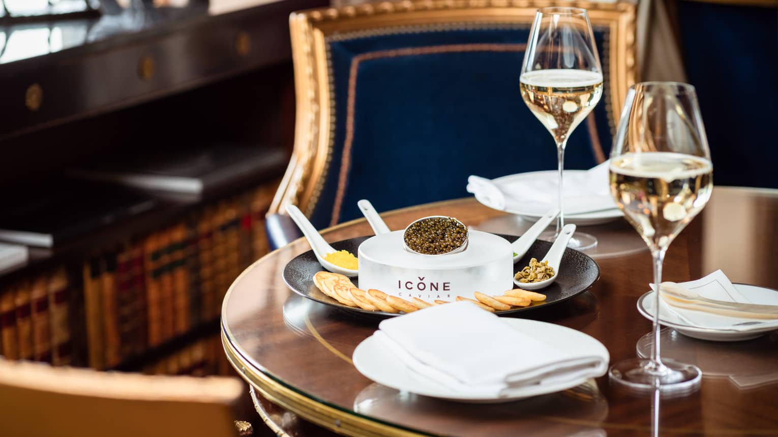 Caviar and crackers next to glasses of wine.