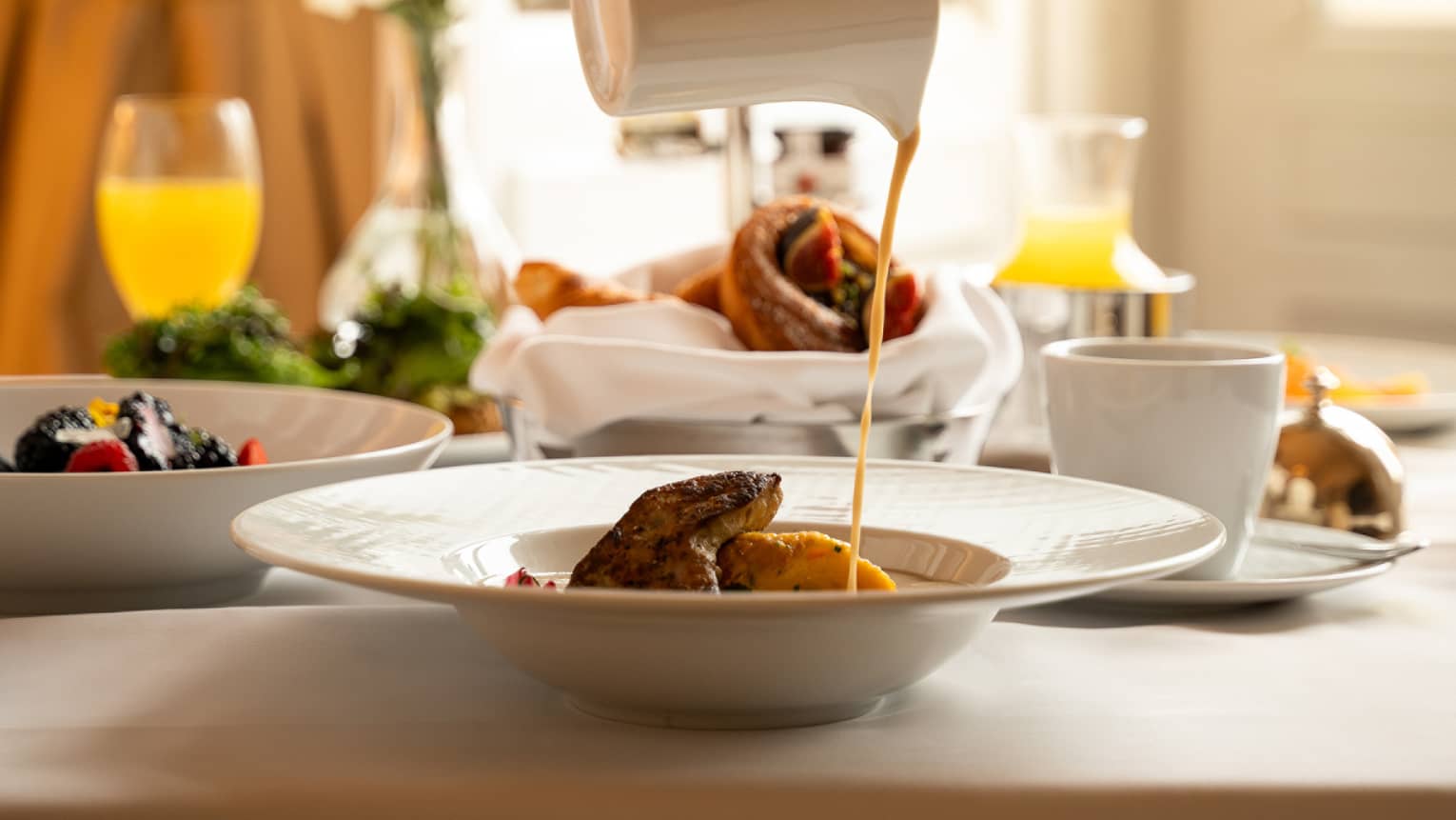 A culinary dish served on a white dish with glasses of juice