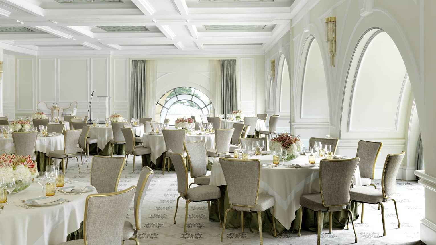 Small banquet tables in Rast Meeting Room with white decor, arched doorways