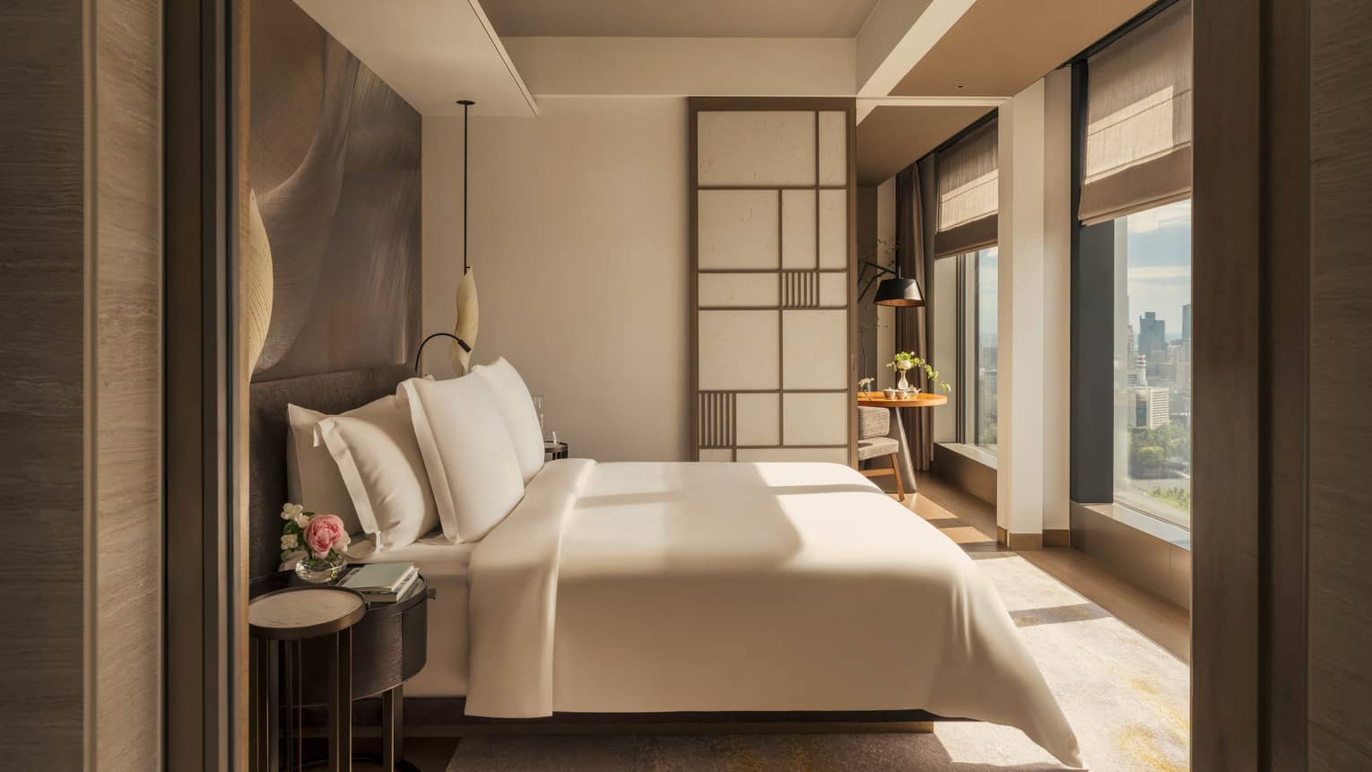 Luxury hotel room with king bed facing a wall of windows and contemporary Japanese design
