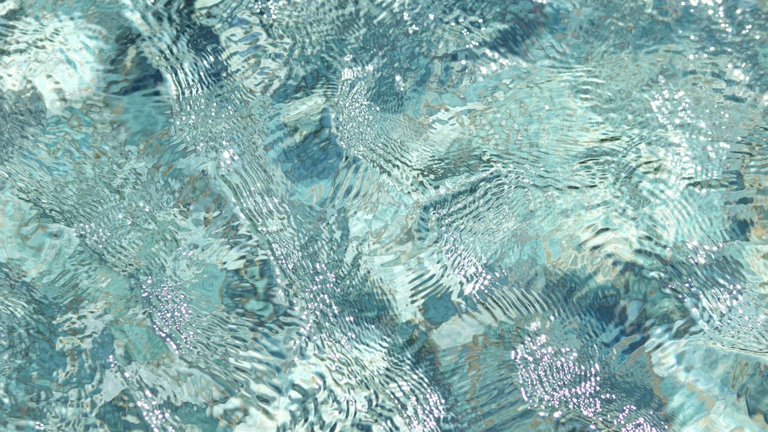 Ripples and wavelets on the surface of turquoise blue water.