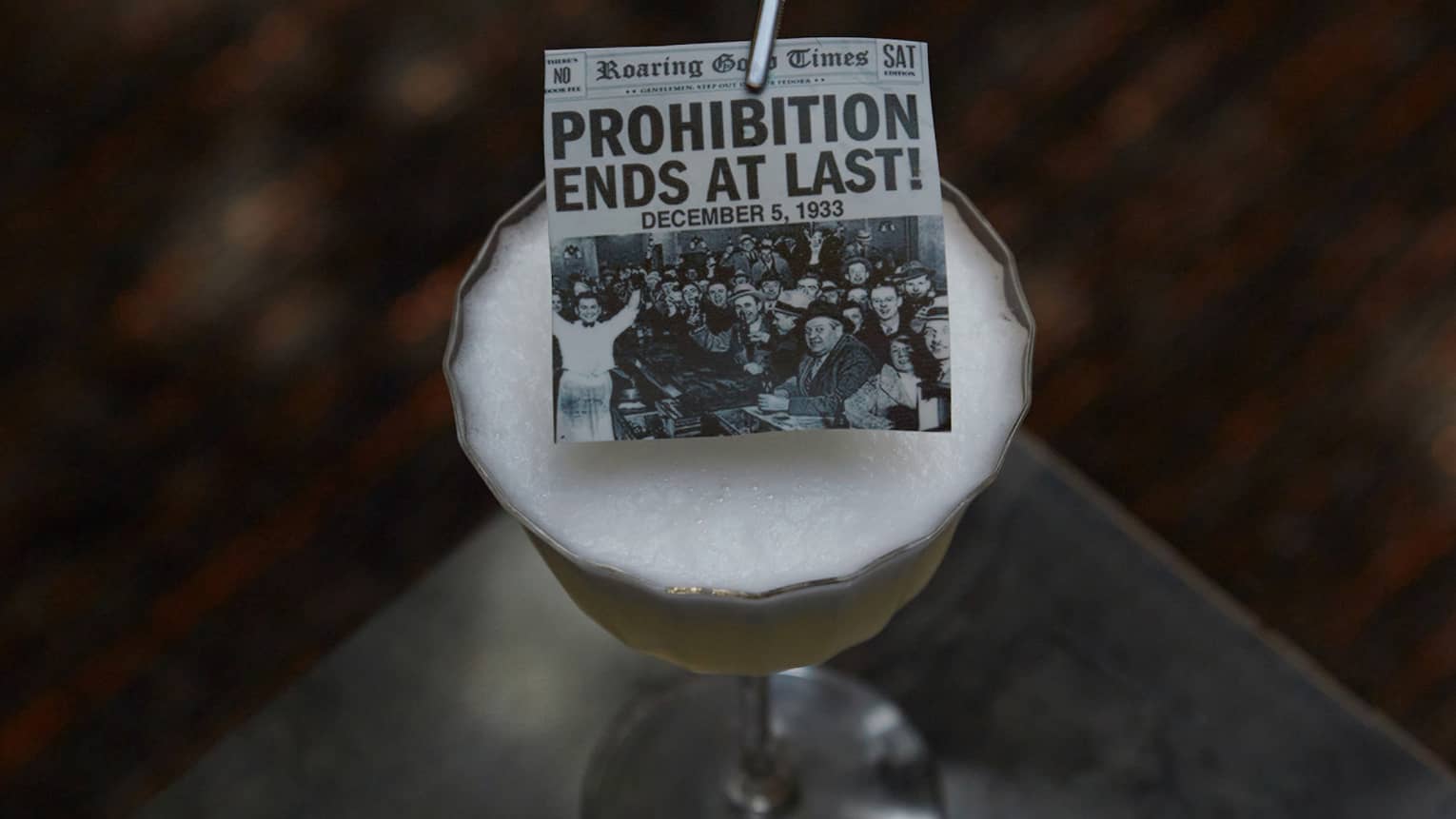 A cocktail with newspaper garnish.