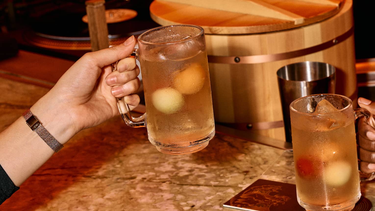 Two high-ball cocktails on stylish green quartz bar counter