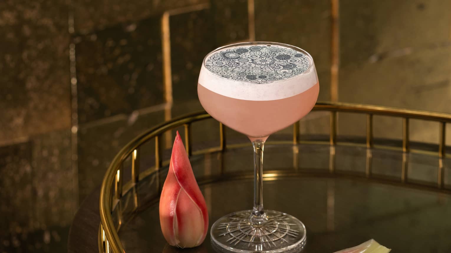 Ribena Haze signature cocktail in stemmed glass on cocktail trolley with pink flower garnishes