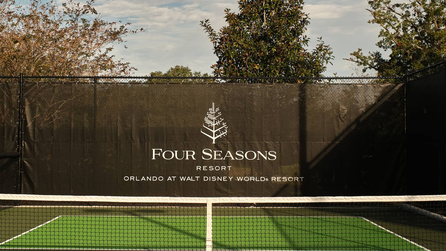 A pickleball court with trees in the background