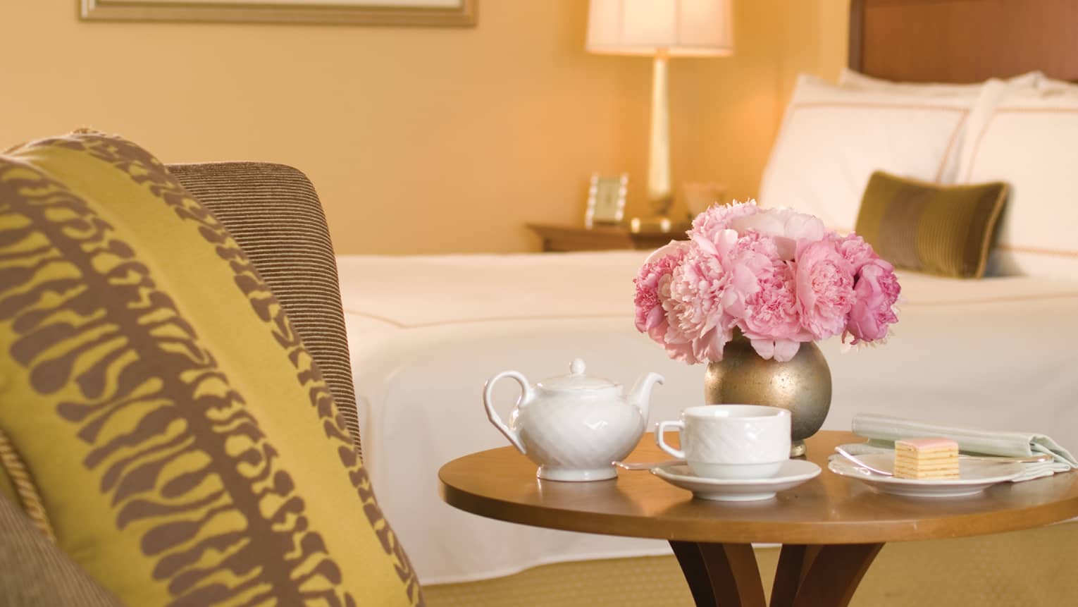 Terrace City-View Room close-up of white teapot, cup, gold vase with pink flowers on beside table
